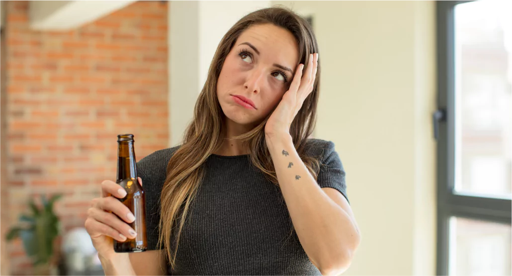 A lady holding alcohol bottle and thinking about something