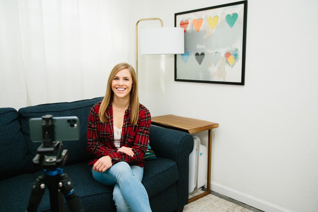 Amanda Horvath filming a video with an iPhone on a tripod.