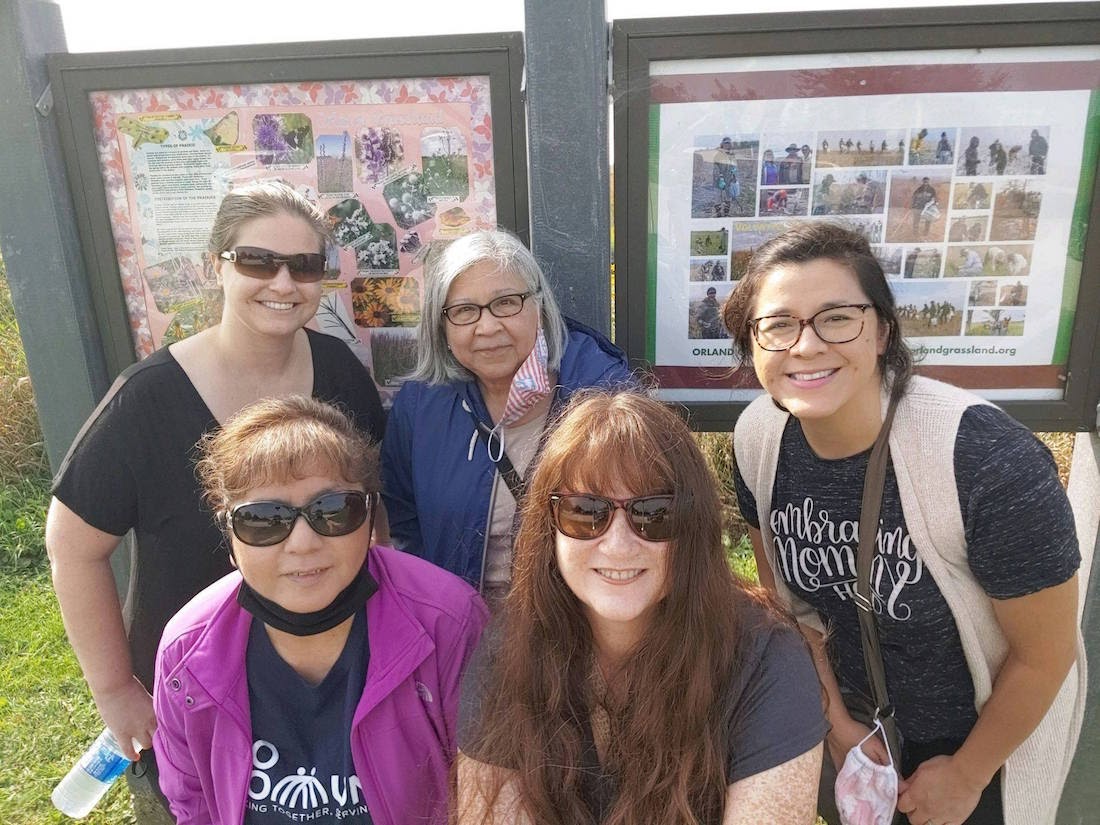 corporate philanthropy: Smiling group of women in front of event photos