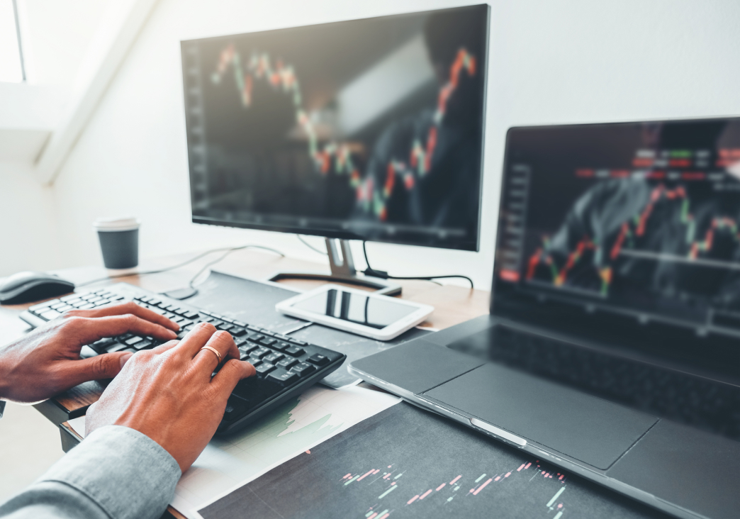 Man typing on desktop computer looking at stocks