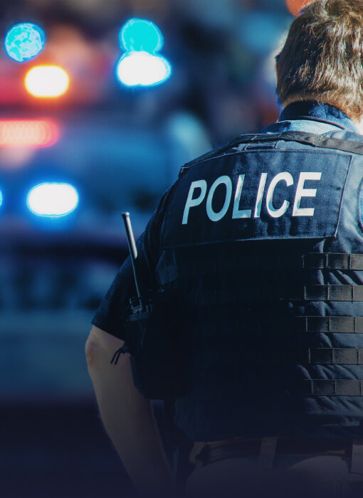 Police officer with back to camera wearing bullet proof vest