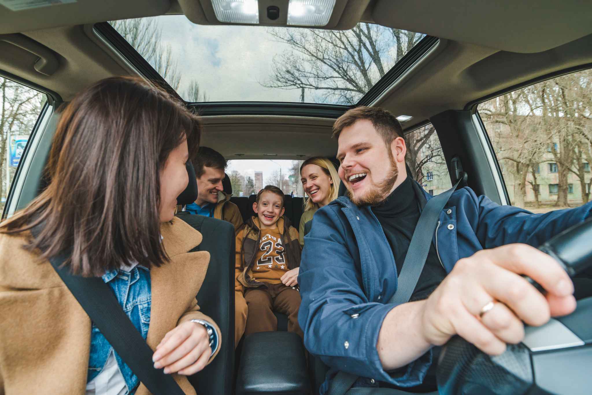 Happy family driving in car while looking at each other