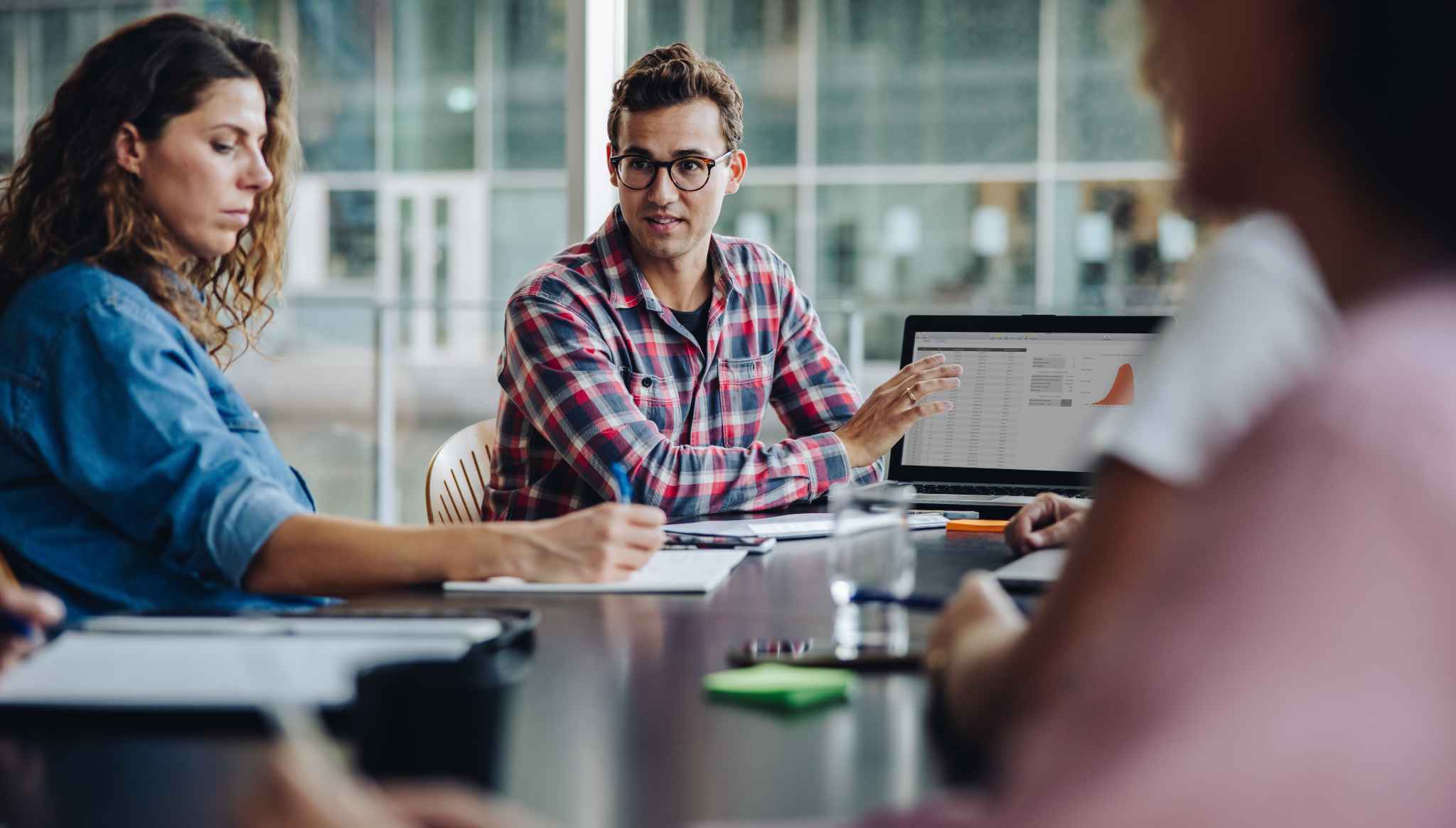 Happy office workers discuss work at a table