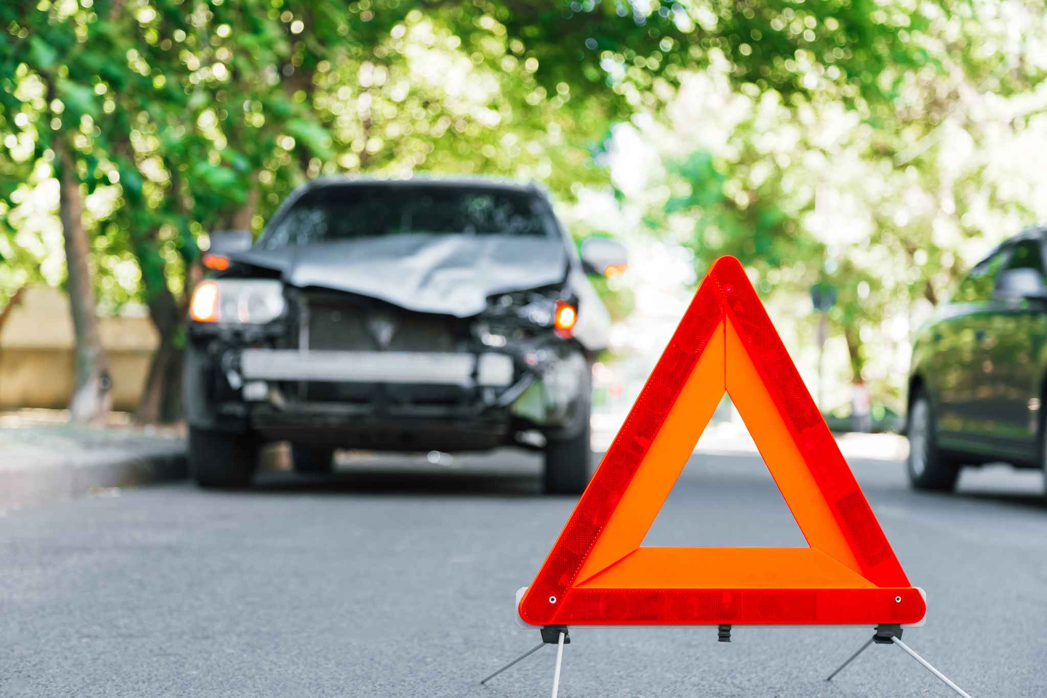 Accident on the side of the road with safety triangle in front of car