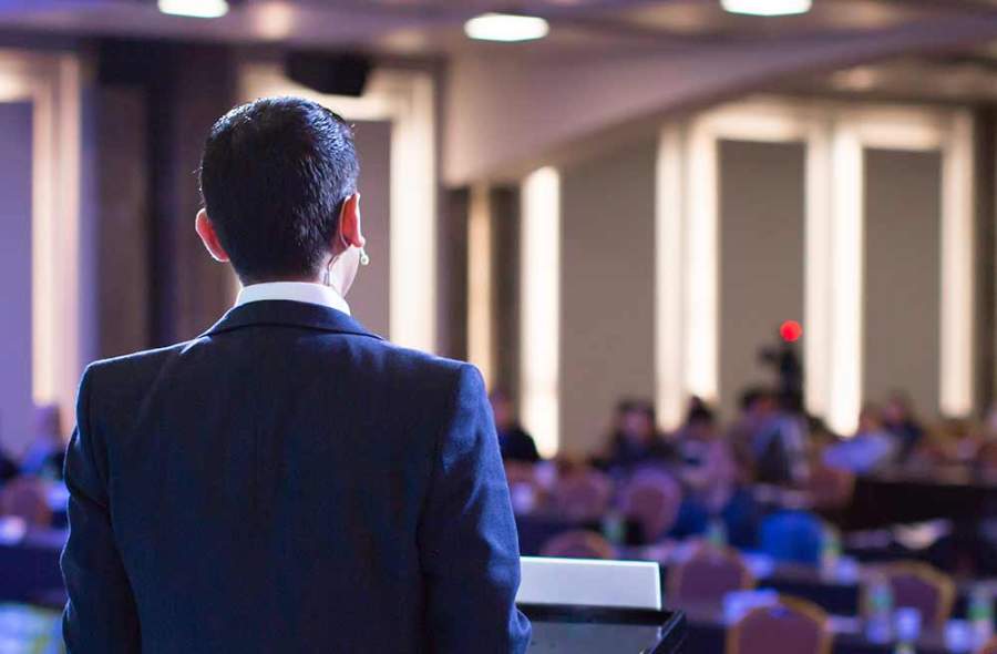 Man presenting at podium to group of people