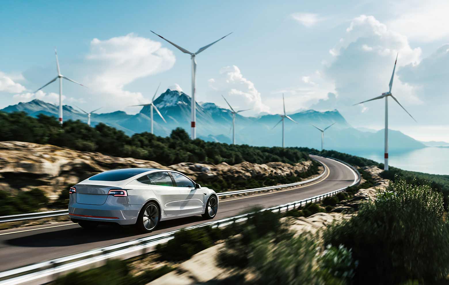 Electric car drive on the wind turbines background. Car drives along a mountain road. Electric car driving along windmills farm.