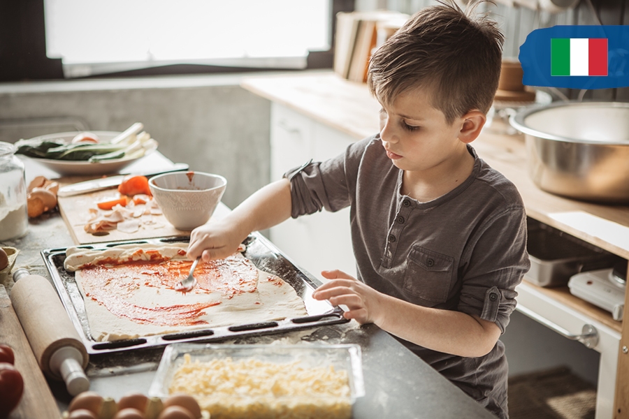 Kids can travel the world from home by cooking as an activity, like pizza for Italy.