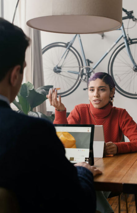 Image of people working together sitting at a desk on their computers