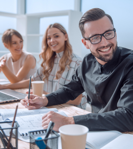 3 young business workers smiling and confident in a meeting.
