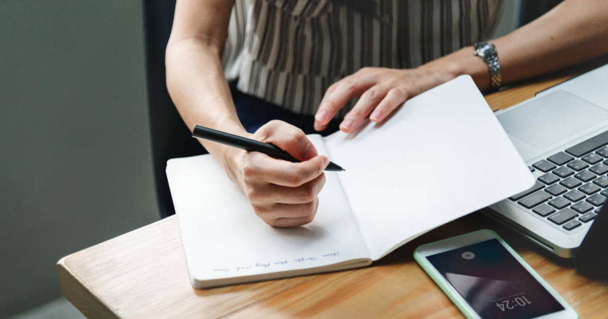 Woman writing on a piece of paper.