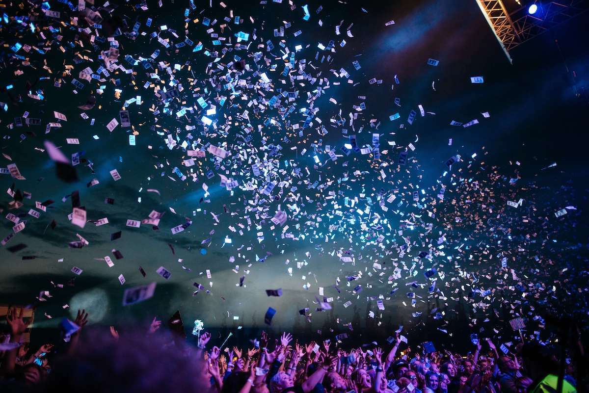 Konfetti som skjuts ut över en stor publik på en konsert