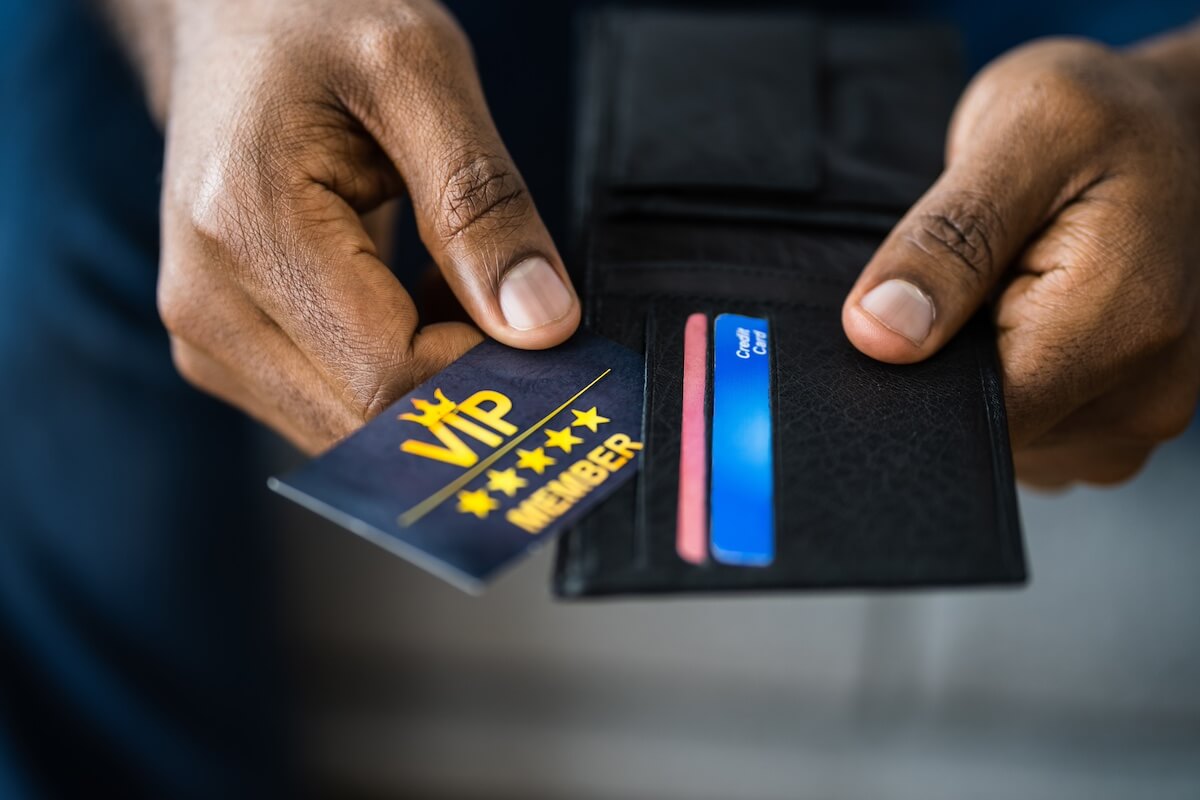 A person takes a VIP membership card for a customer loyalty program out of their wallet