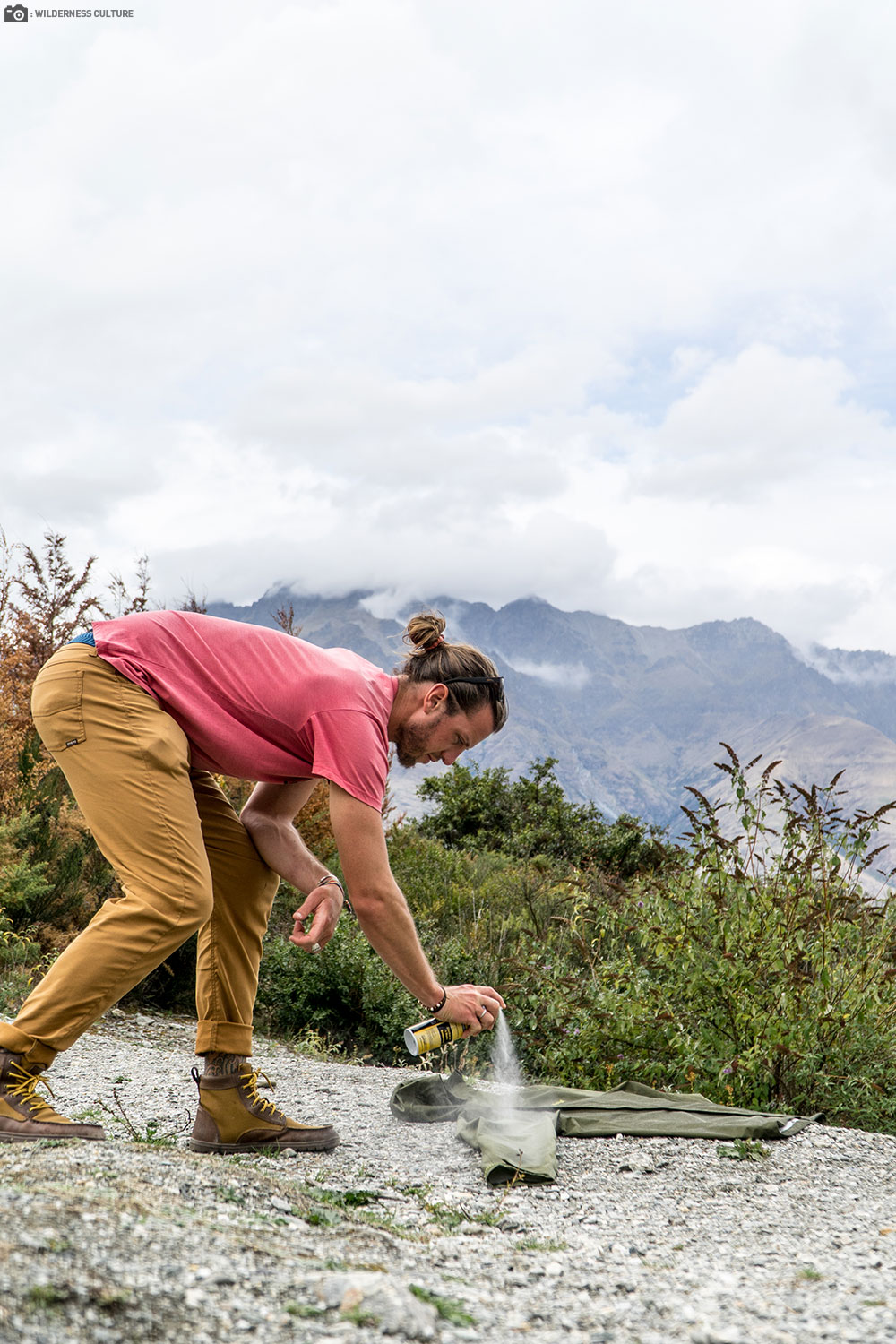 A Gentleman Spraying his Clothes with Sawyer Permethrin Fabric Insect Repellent to his Jacket