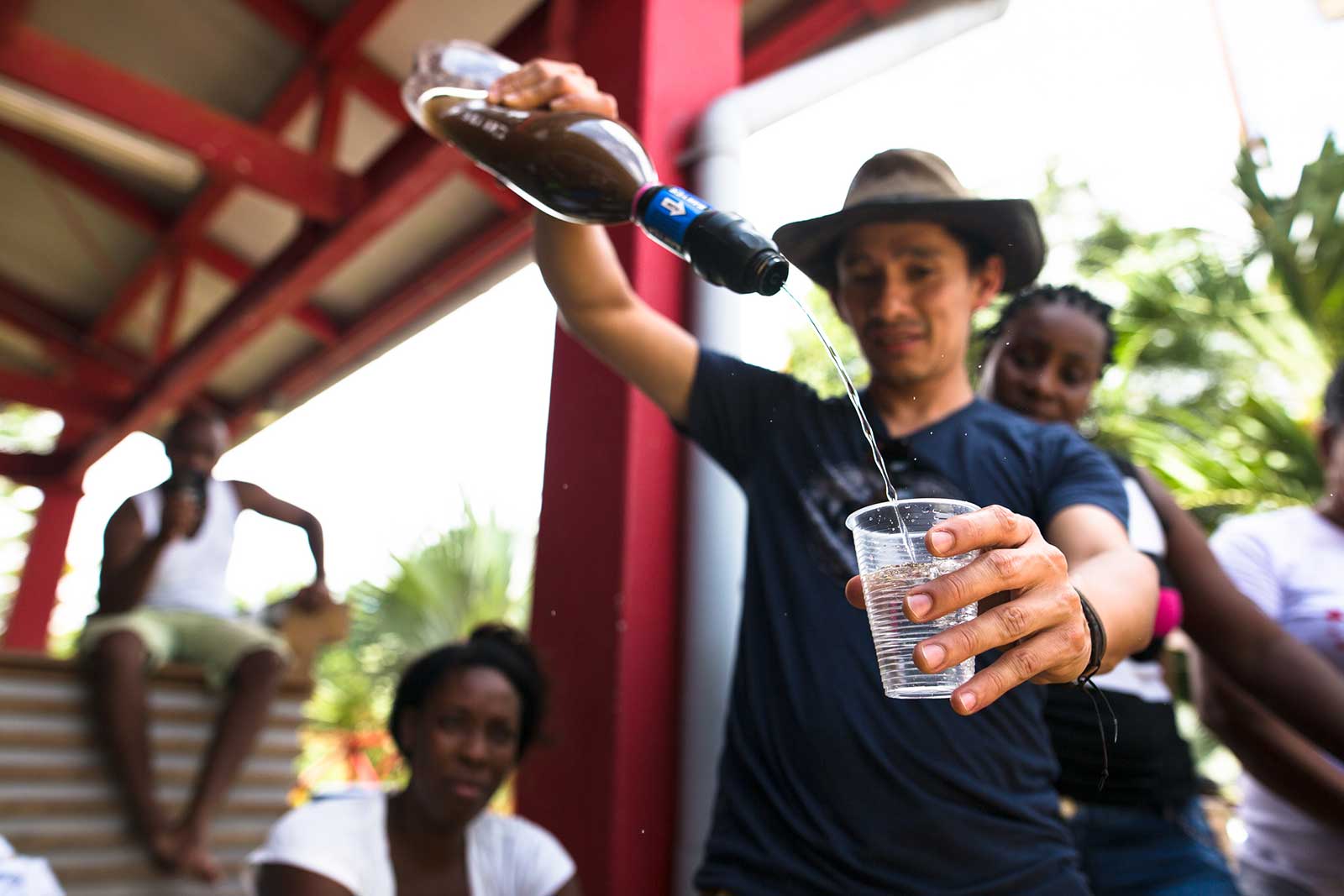Man pours filtered water from Sawyer filter into cup