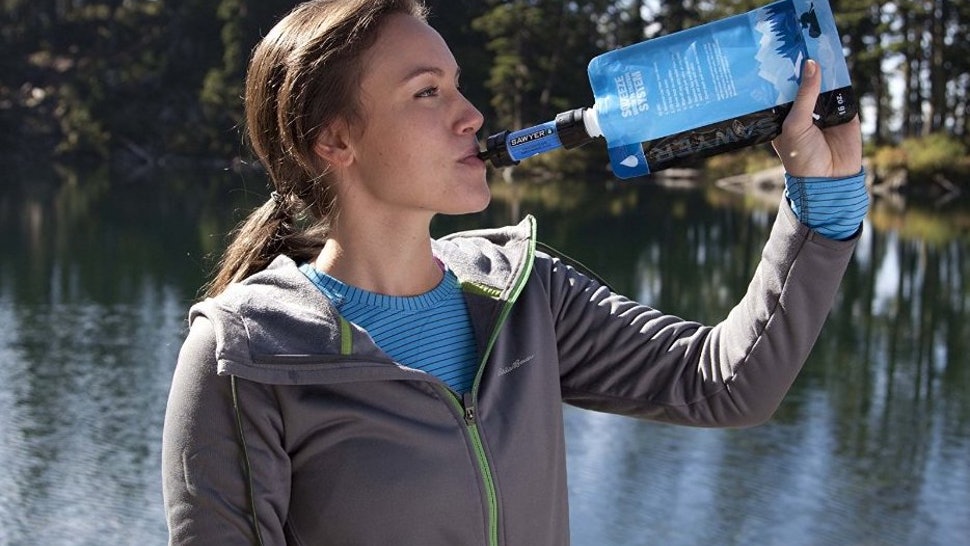 Woman drinks from Sawyer squeeze water filter