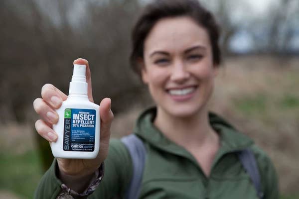 Woman holding sawyer insect repellent