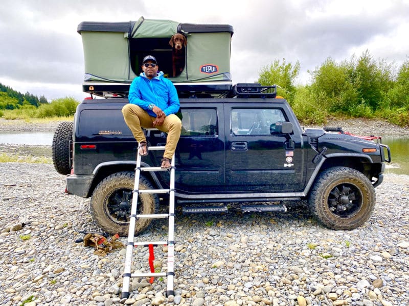 Chad Brown sitting on ladder to truck camper