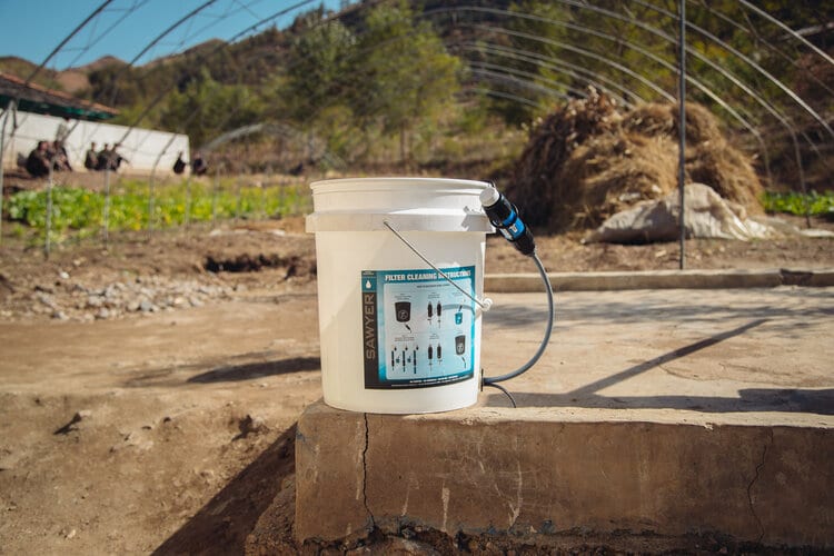 Sawyer bucket filtration system in an international village