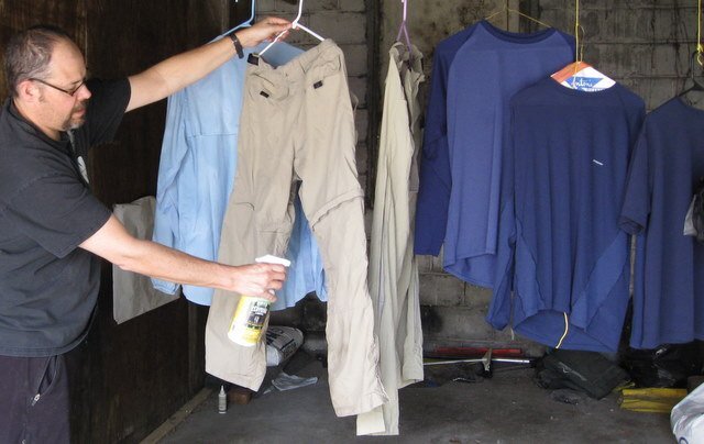 Man spray treating clothing