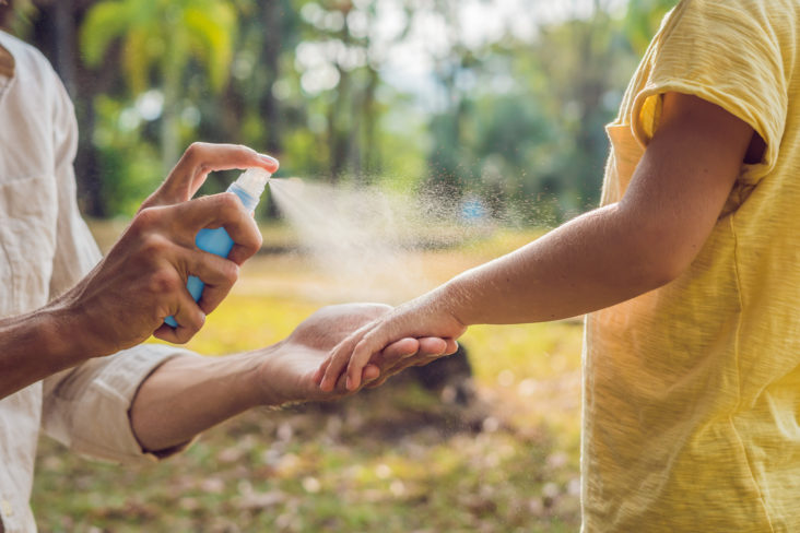 Dad and son use mosquito spray