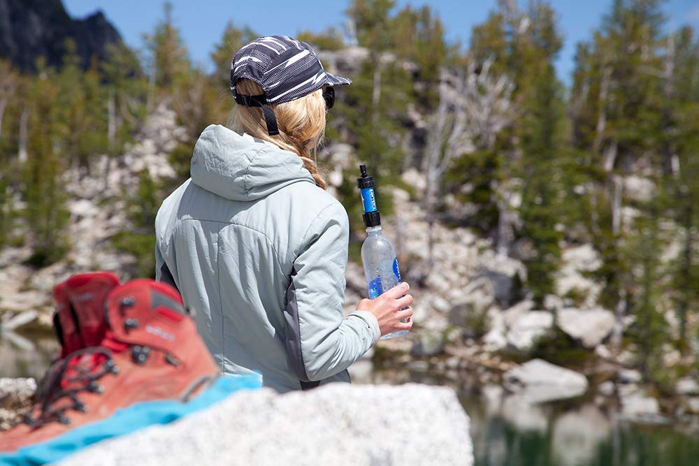 Woman with water bottle and Sawyer filter outdoors