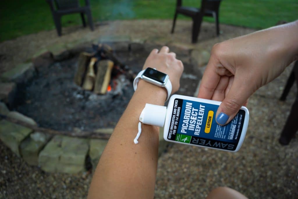 Person applying Sawyer insect repellent lotion to arm