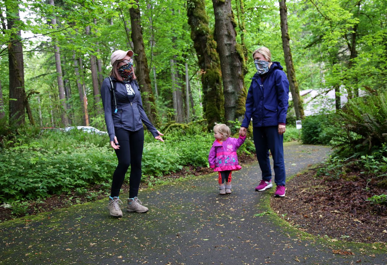 Two people and a child on a park trail