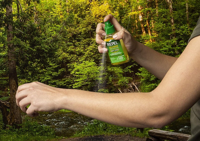 Person sprays insect repellent on arm