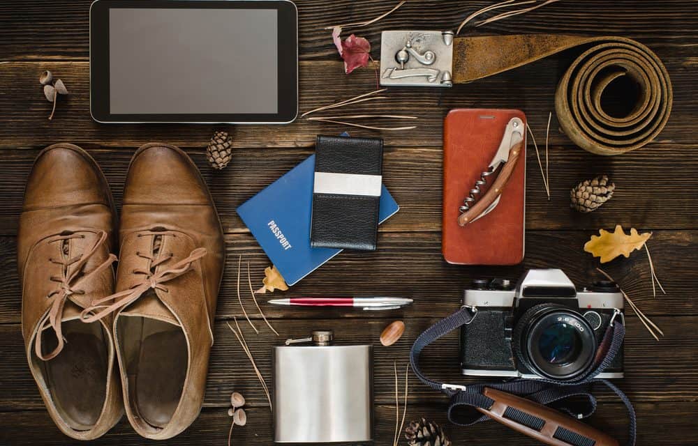 Shoes, passport, camera, belt, iPad and other various items on table