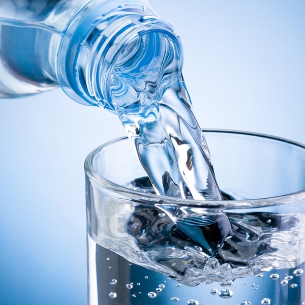 Water being poured into glass from bottle