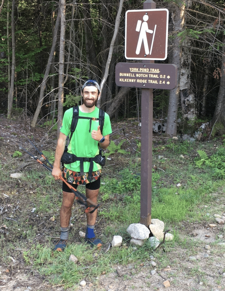 Will Peterson next to trail sign