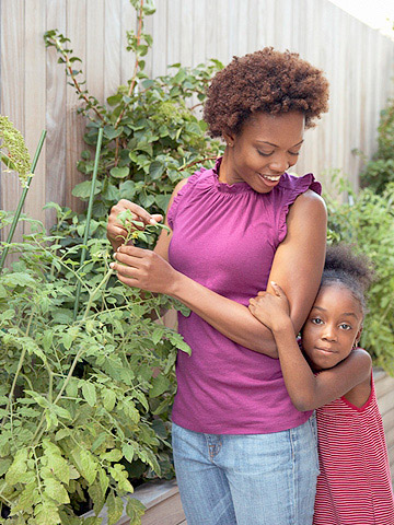 Woman next to plans being hugged by daughter