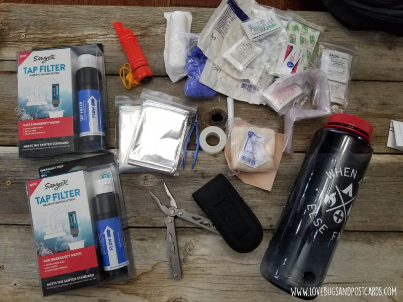 Sawyer tap filters in packaging next to reusable water bottle and other gear