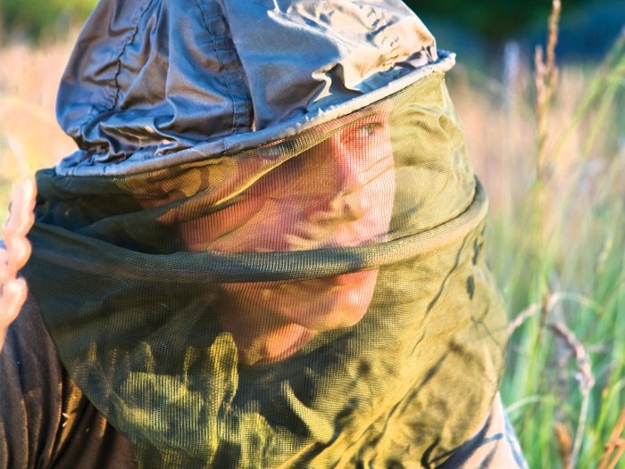 Person wearing a hat with bug screen