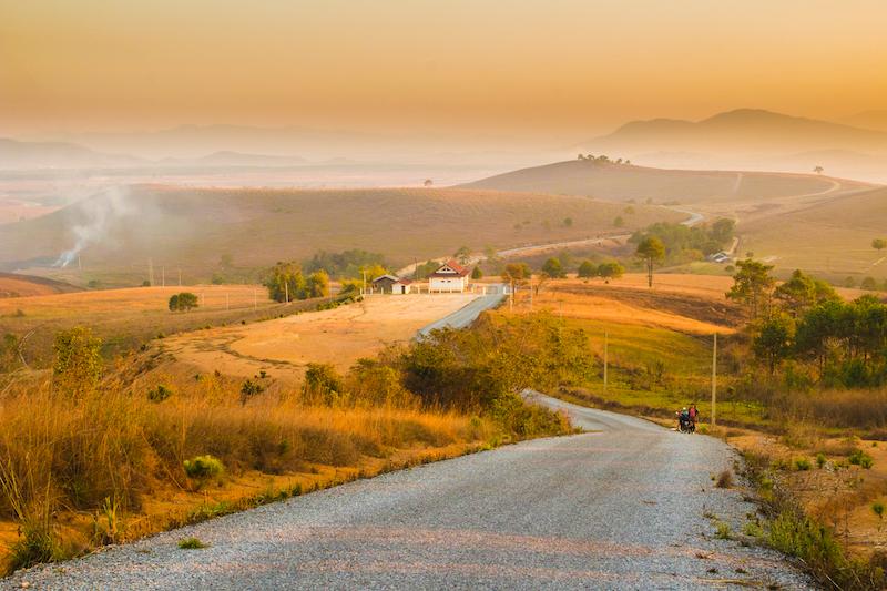 A gravel road to a house in the mountains