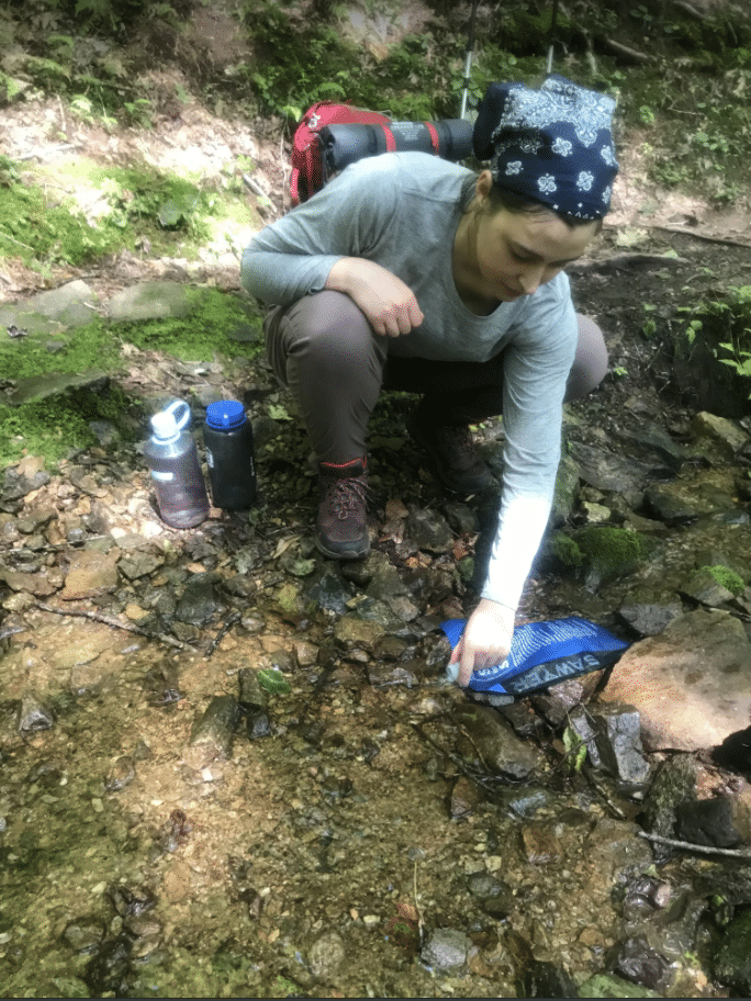 Person filtering water from stream