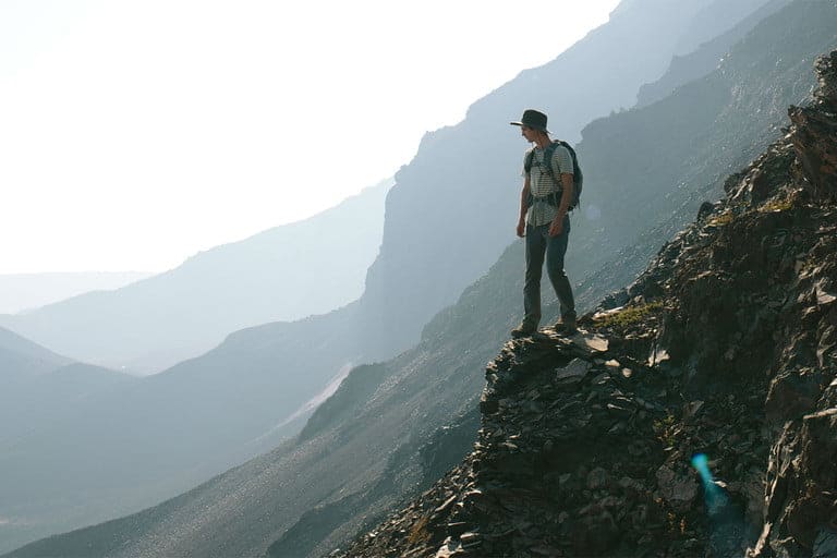 Hiker standing on rock staring below