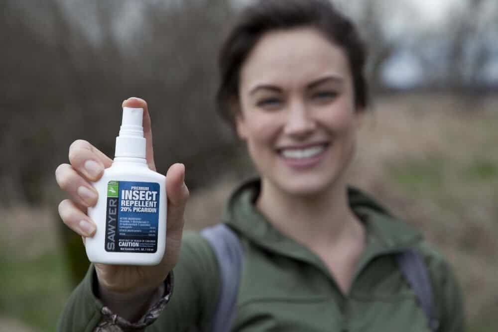 Woman holding insect repellent