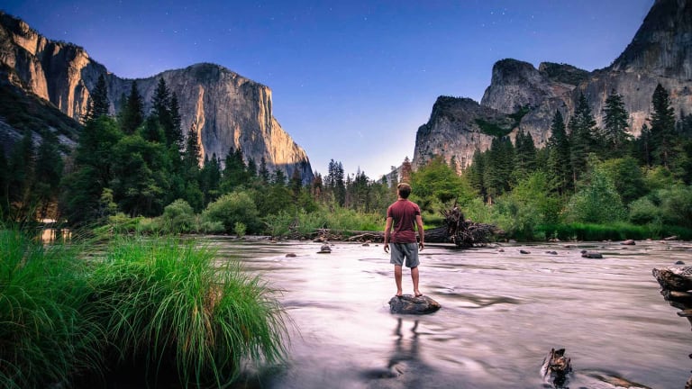 Person standing on rock in river