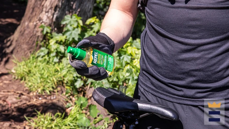 An indiviudal using Repel insect repellent prior to a bike ride. 