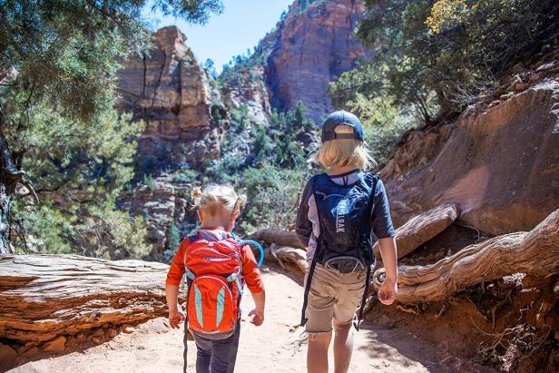 Two young children walking on a trail 