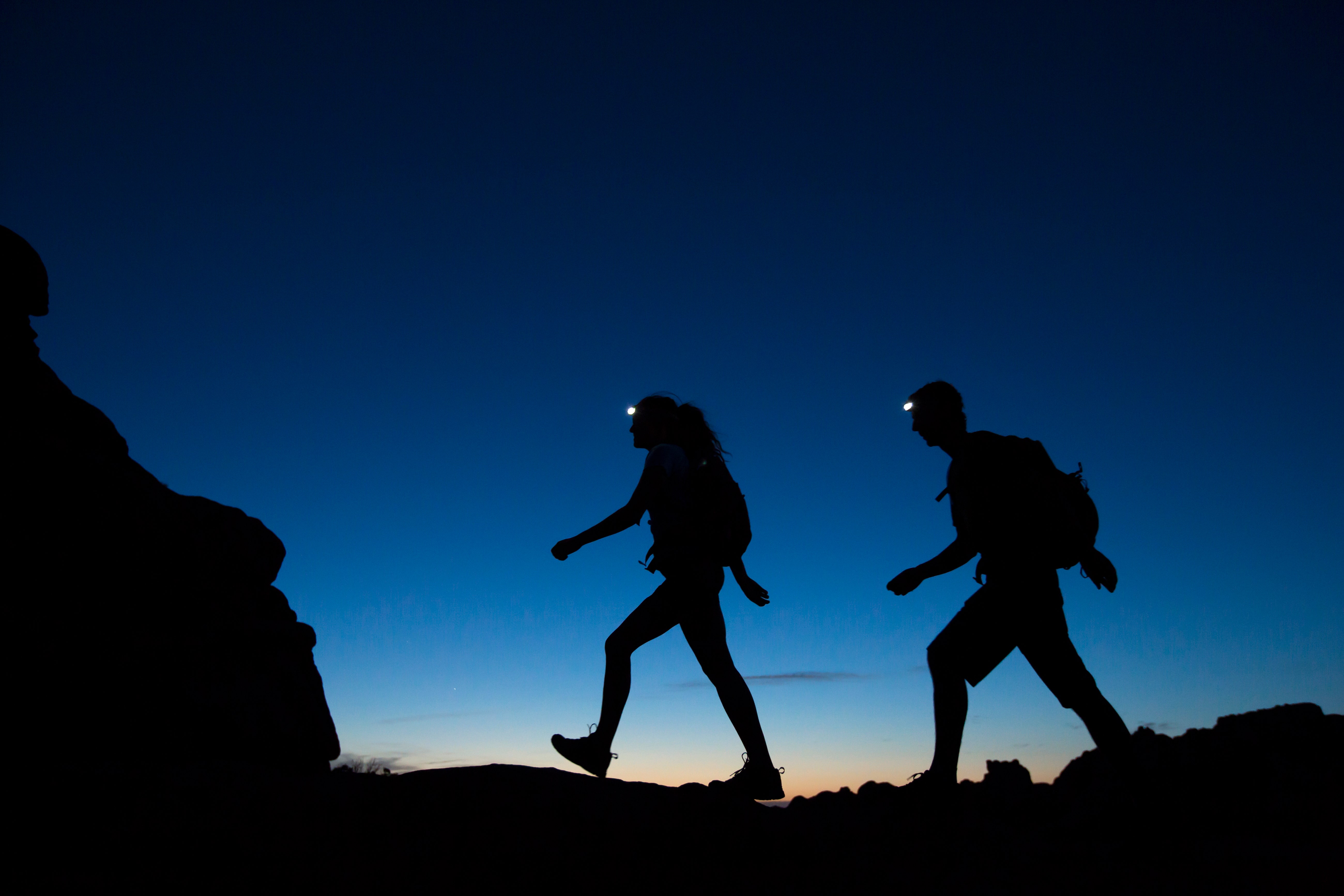 A couple hiking at night in Arches National park.Jordan Siemens via Getty Images