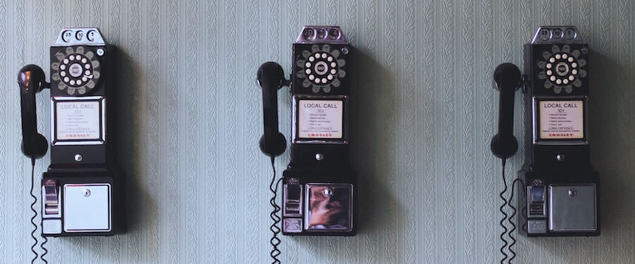 three old telephones hanging on the wall travel nursing phones interview