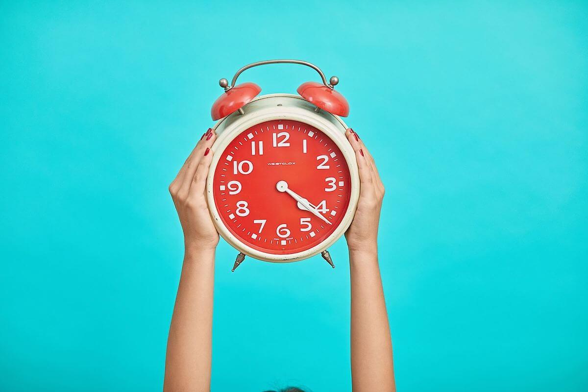 red clock on blue background time is of the essence for travel nurses