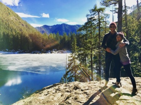 photo of brit hamstra with partner standing on rock in front of lake and trees pediatric nurse