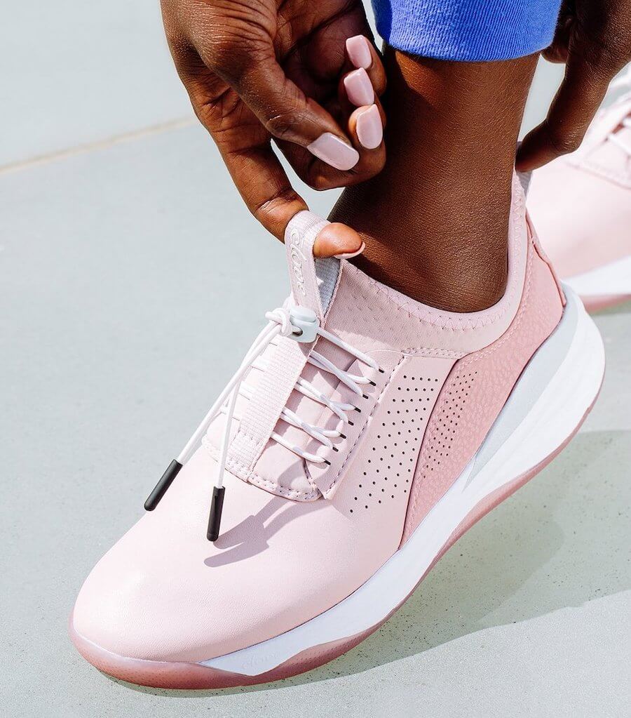 woman putting on pink nursing shoe clove nursing shoes holiday gift ideas for nurses