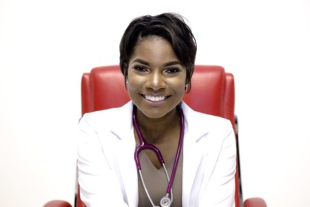 Nurse Boss tanisha terry sitting in red chair ready to see a patient