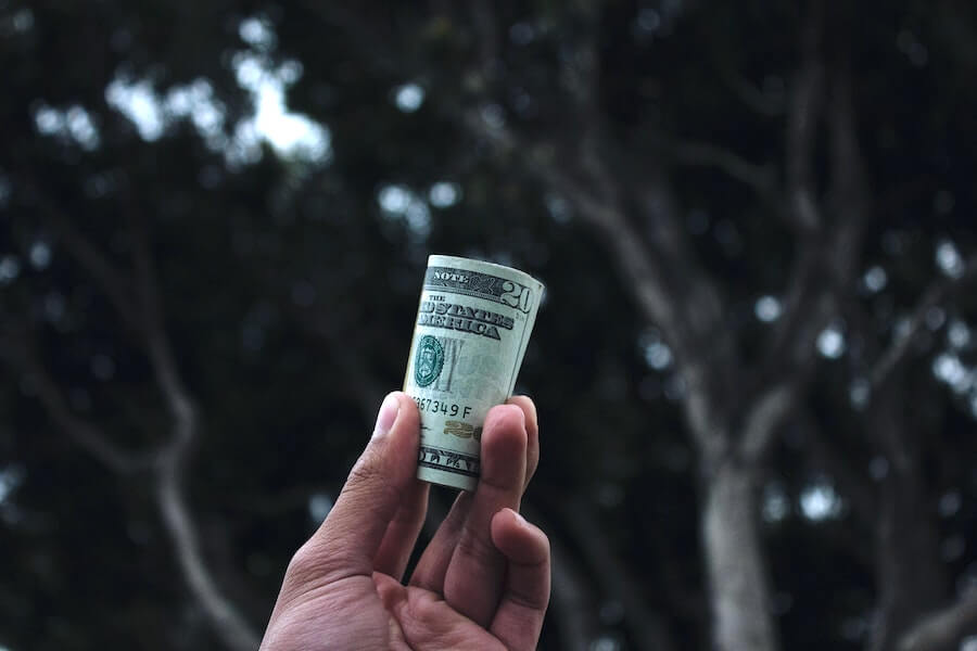 hand holding 20 dollar bills up highest paying nursing jobs 2021