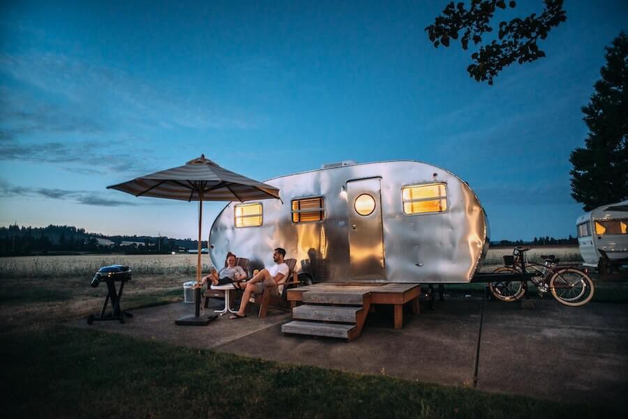 two people sitting outside camper van travel nursing housing from staff nurse to travel nurse