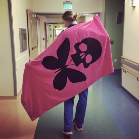 nurse erin kilroy in unit hallway holding up designed blanket